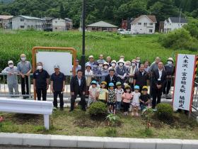 植樹式に参加した、地区の方や磯鶏保育所園児の皆さんが 植樹したツツジを前にして集合して撮影した写真