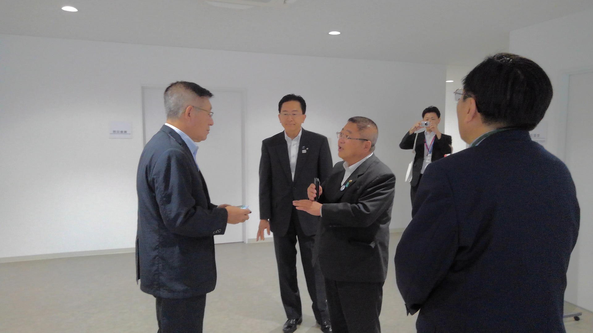 市長と男性が向かい合うように話をし、両側から2名の男性がその様子をみている写真
