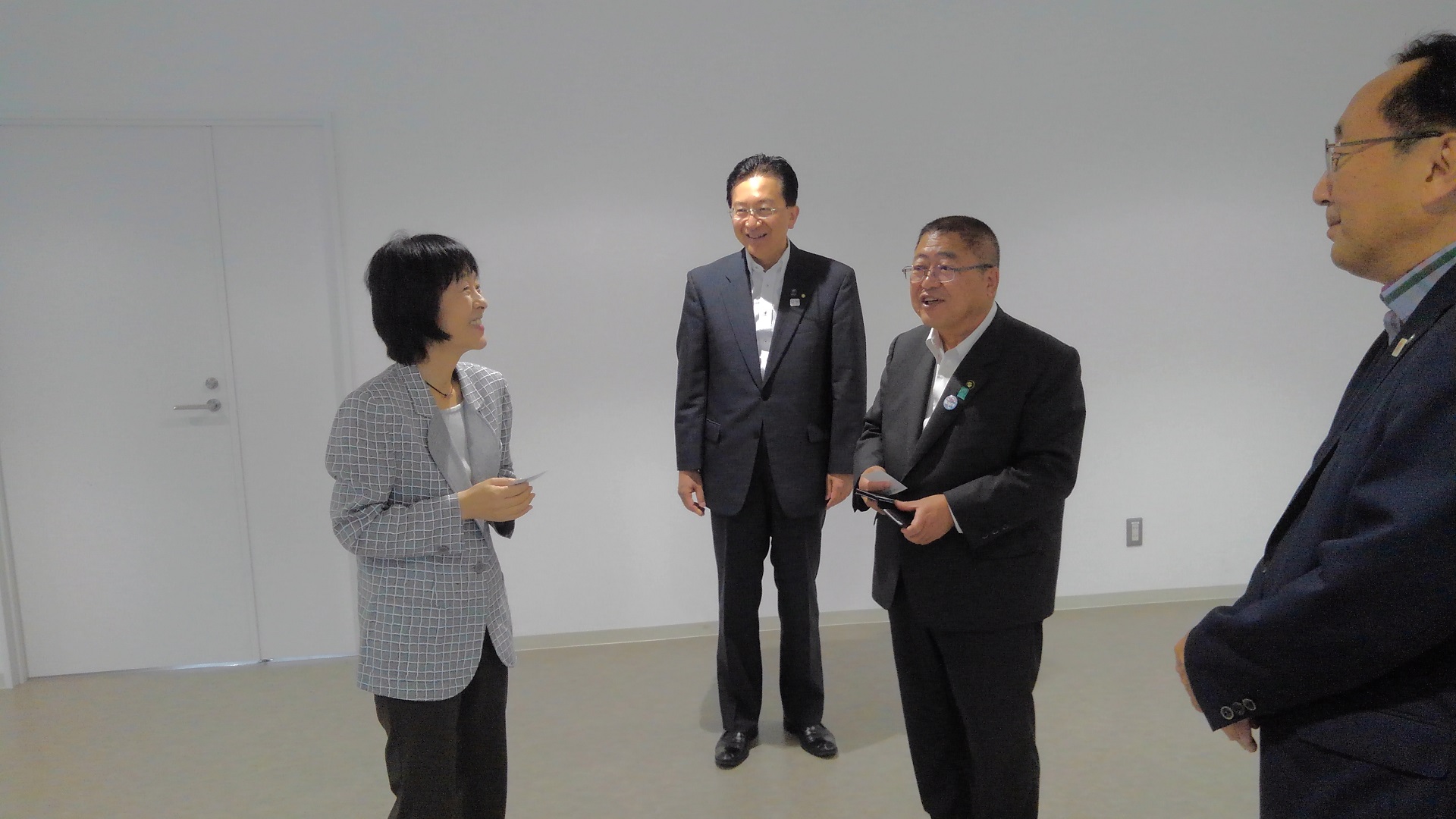 グレーのジャケットを着た女性、市長、2名の男性が立って話をしている写真