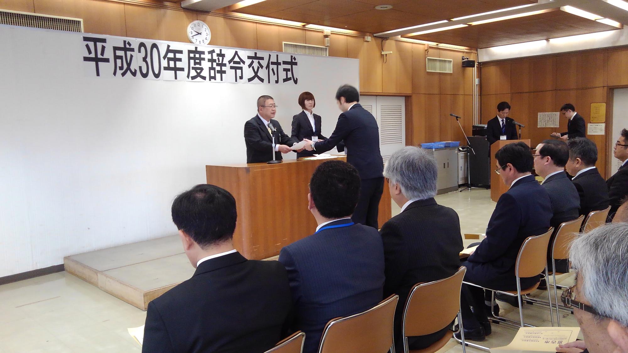 演台の向かい側から職員の方へ辞令を渡している様子の市長の写真