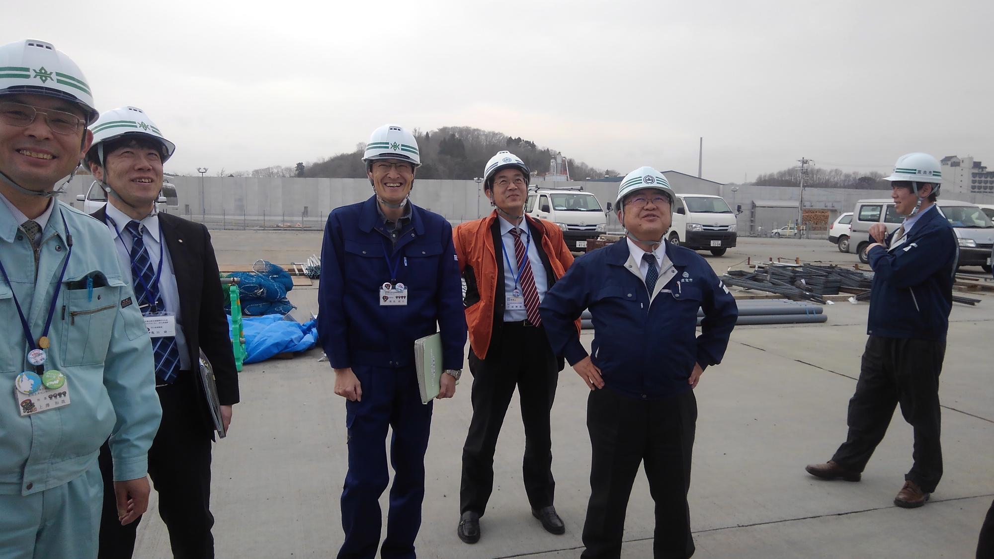 ヘルメットを被る市長や関係者の方々が立っている写真